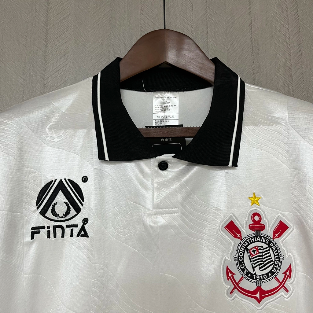 Em 1992, o Corinthians utilizou uniformes fornecidos pela marca brasileira Finta, com destaque para a camisa titular predominantemente branca. Esta peça apresentava gola polo preta e o logotipo da Finta no lado direito do peito, enquanto o escudo do clube ocupava o lado esquerdo. O patrocínio da Kalunga estava estampado no centro da camisa, reforçando a parceria da época. Este design clássico é lembrado com carinho pelos torcedores e colecionadores, simbolizando uma era significativa na história do clube.